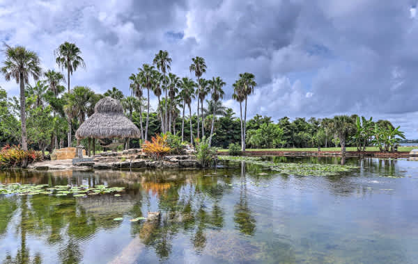 Floridian shoreline with thatch hut and palm trees near vacation rental