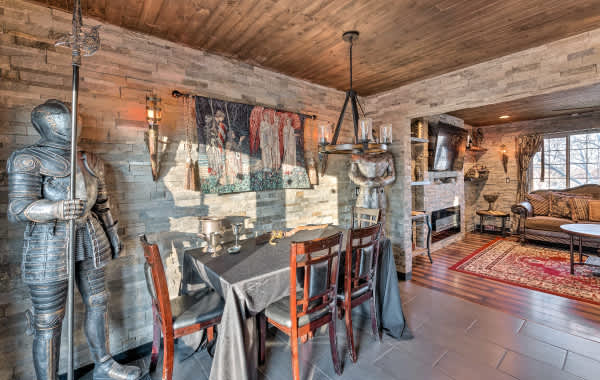 Two suits of armor and a medieval tapestry above a table with goblets in vacation rental