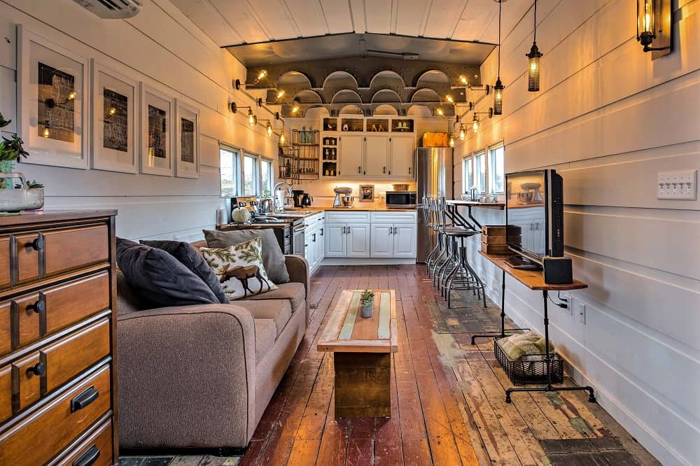 Living room and kitchen with ample lighting and rustic design elements