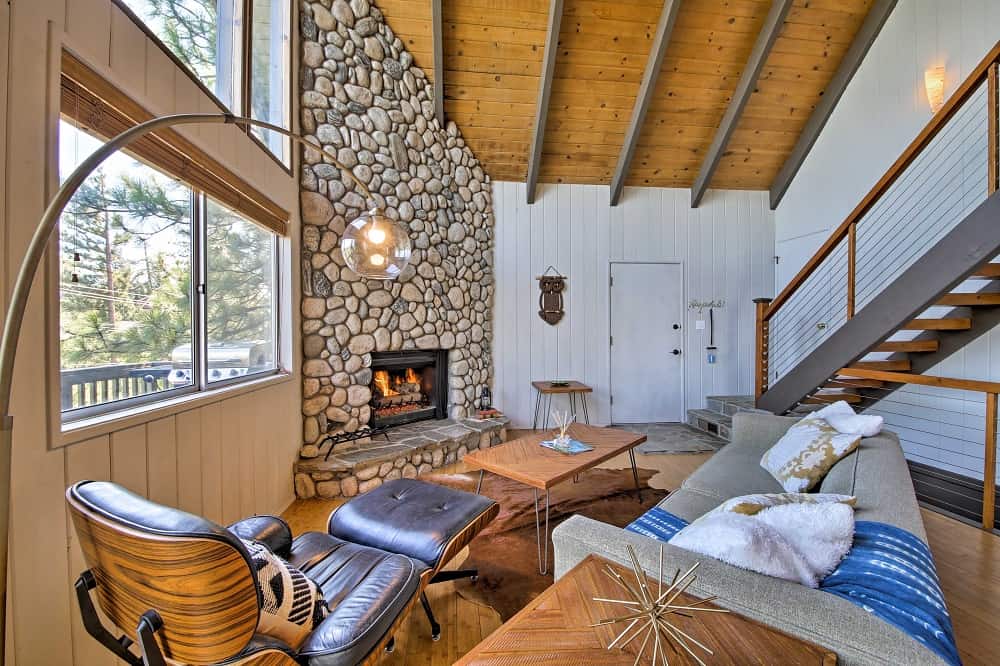 Chic living room with lots of natural light and stone fireplace