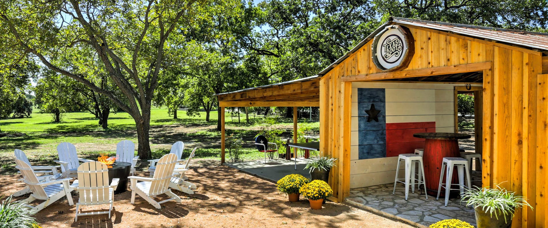 Outdoor fire pit area surrounded by lawn chairs, next to a covered patio, since fire pits are one of the best rental backyard ideas.