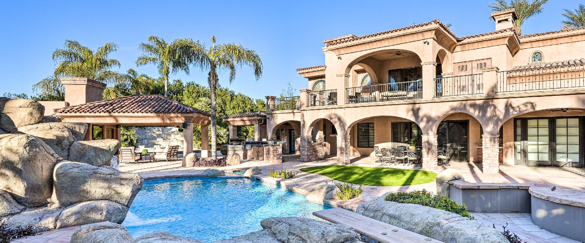 Photo of a villa vacation rental in Paradise Valley, Arizona that has a large private pool and expansive back porch area great for hosting parties.