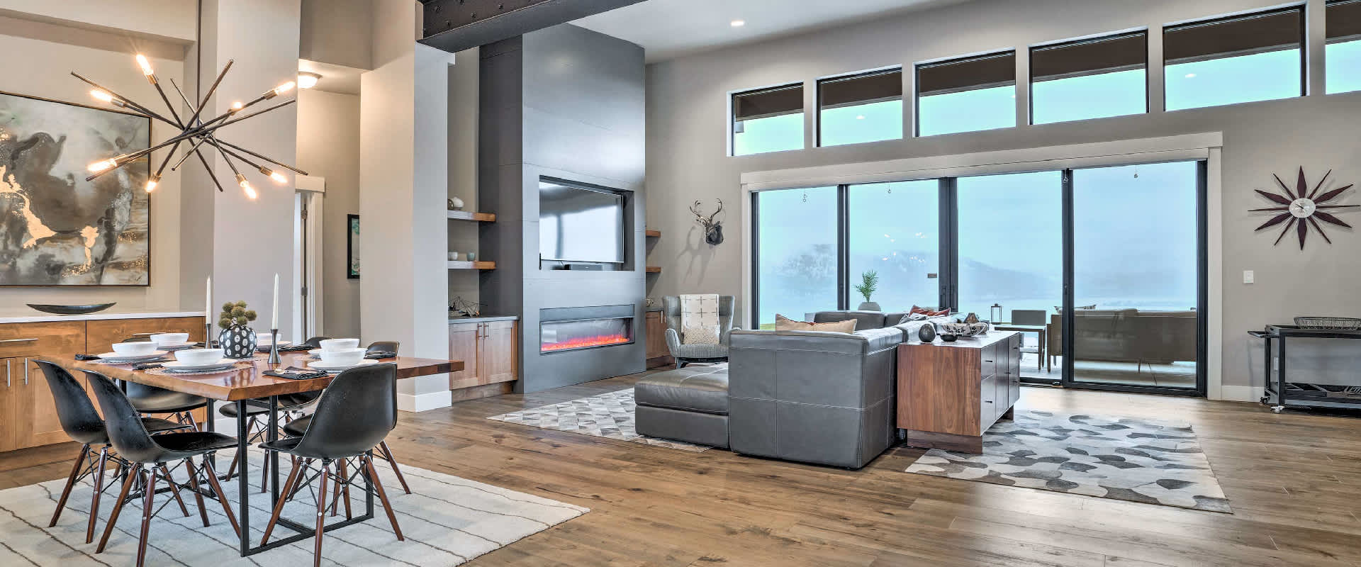 Photo of a large living room space in a vacation rental near Manson, Washington. The large windows overlook a mountainous range during winter.