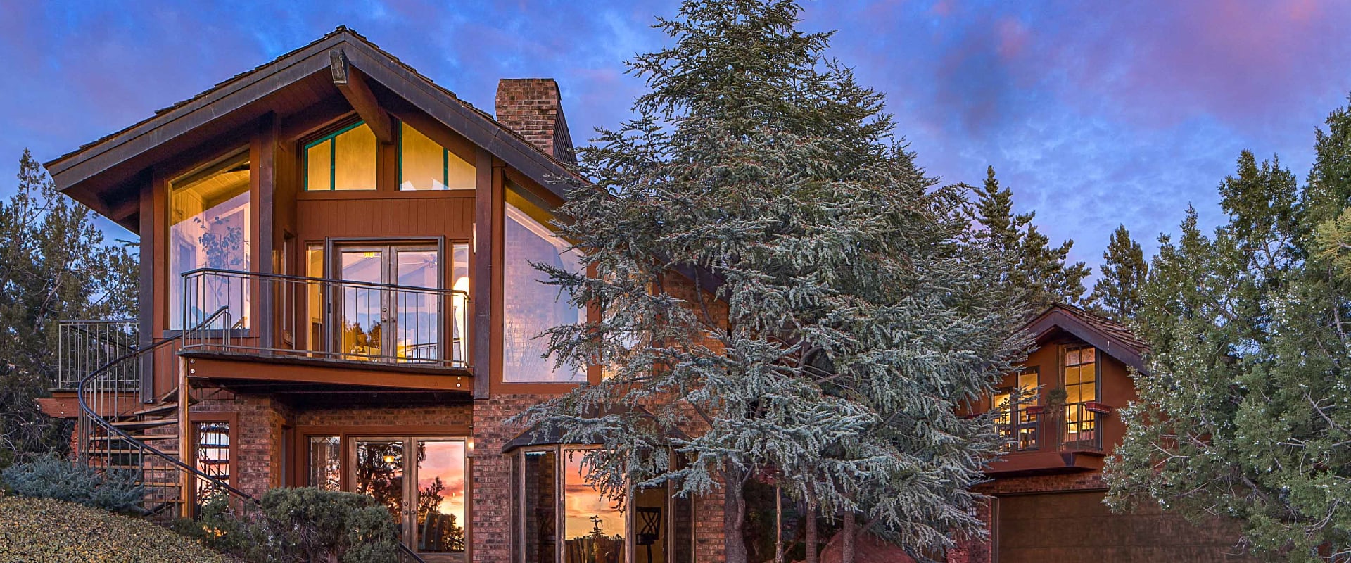 Photo of a stunning vacation rental at dusk with the lights on in Sedona, Arizona.