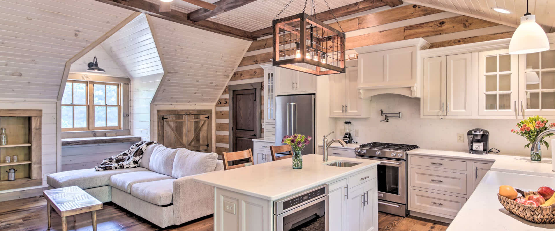 Cozy, bright, cabin kitchen and living space, with wood beams and white walls