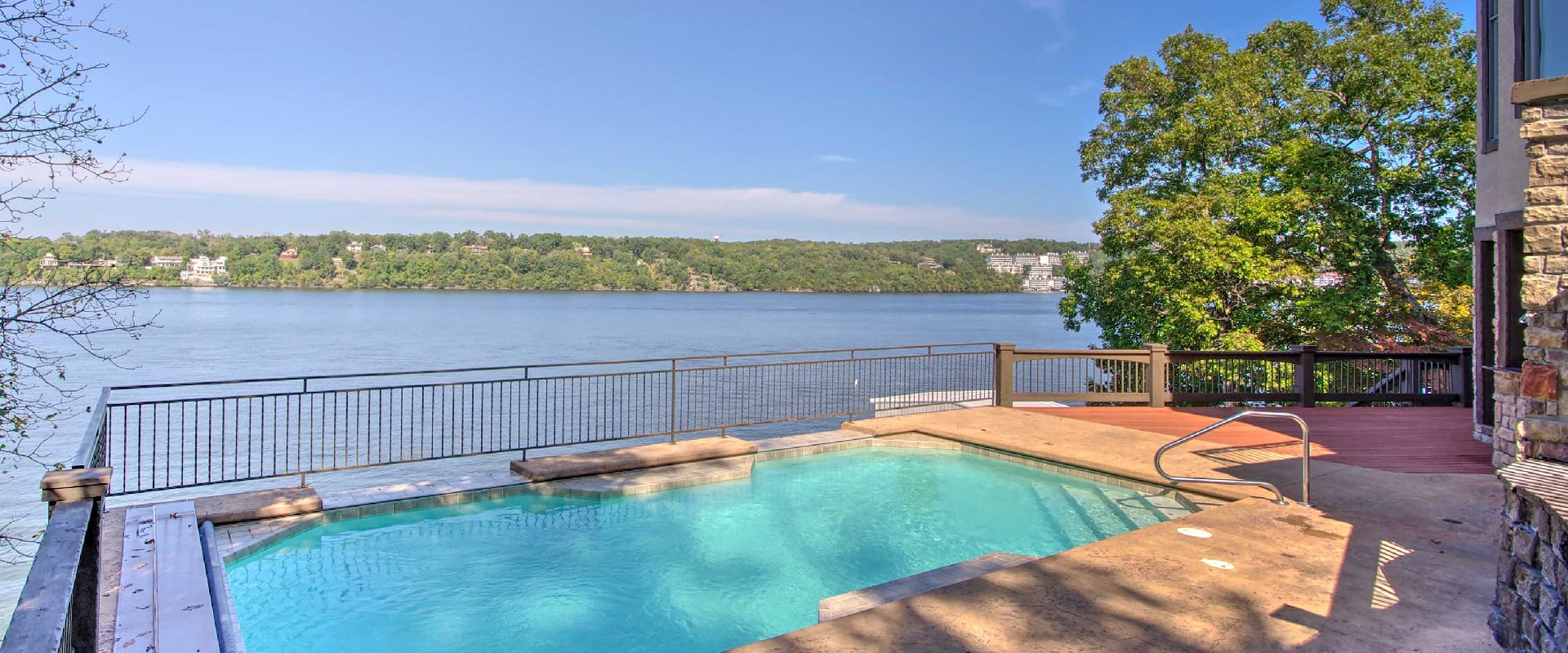 Large deck with an outdoor pool overlooks the Lake of the Ozarks