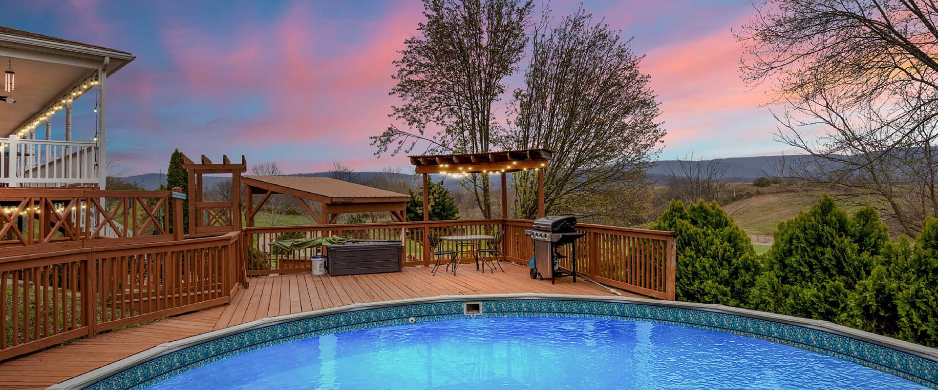 Large deck and outdoor pool overlooks the Virginia mountains at sunset