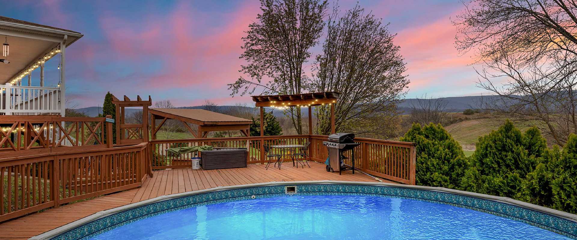 Large deck and outdoor pool overlooks the Virginia mountains at sunset