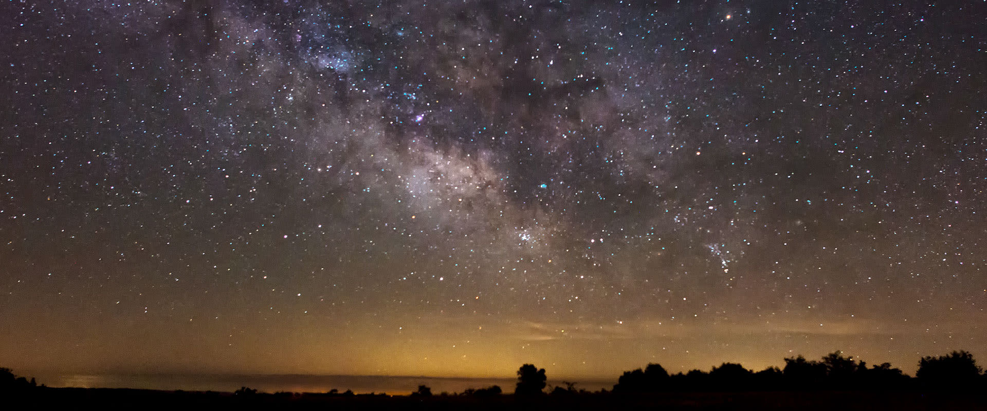 Photo of the Milky Way casting its glow over the water during a serene night near Buffalo National River, Arkansas.