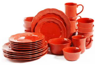 Matching set of orange plates, bowls, and mugs