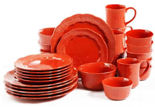 Matching set of orange plates, bowls, and mugs