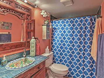 Vacation rental bathroom with ceramic sink and wood-framed mirror