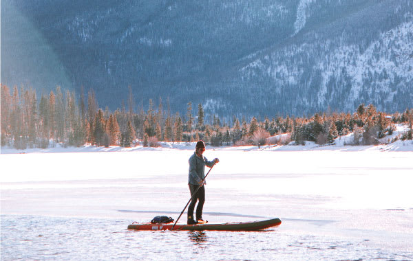 Paddleboarder on snowy Lake Dillon, one of the top things to do in Summit County, Colorado