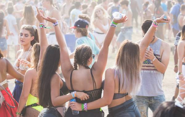 Three friends posing for a picture at the Coachella music festival in Palm Springs, California