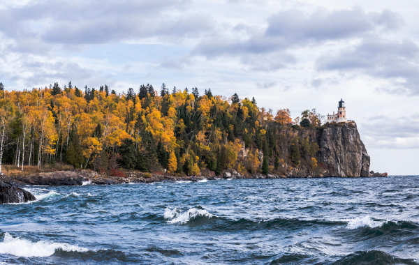 View of Split Rock Lighthouse in Minnesota, surrounded by water and fall foliage