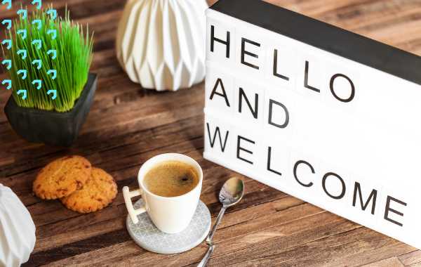 LED welcome sign on wood table with coffee and cookies