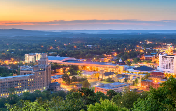 View of downtown Hot Springs, Arkansas with mountains in the distance at sunset