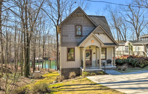 Waterfront vacation rental with an emerald green lake peeking out from behind the home