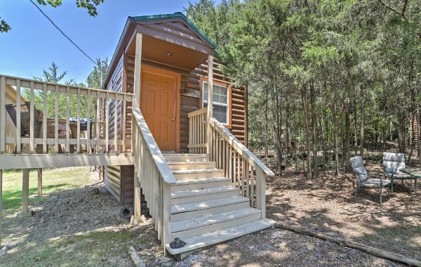 Tiny house rental with furnished patio and seating area next to trees in Branson Missouri near the Ozarks