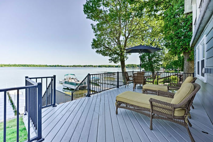 Deck overlooking a private dock and lake at an Albion, Michigan vacation rental