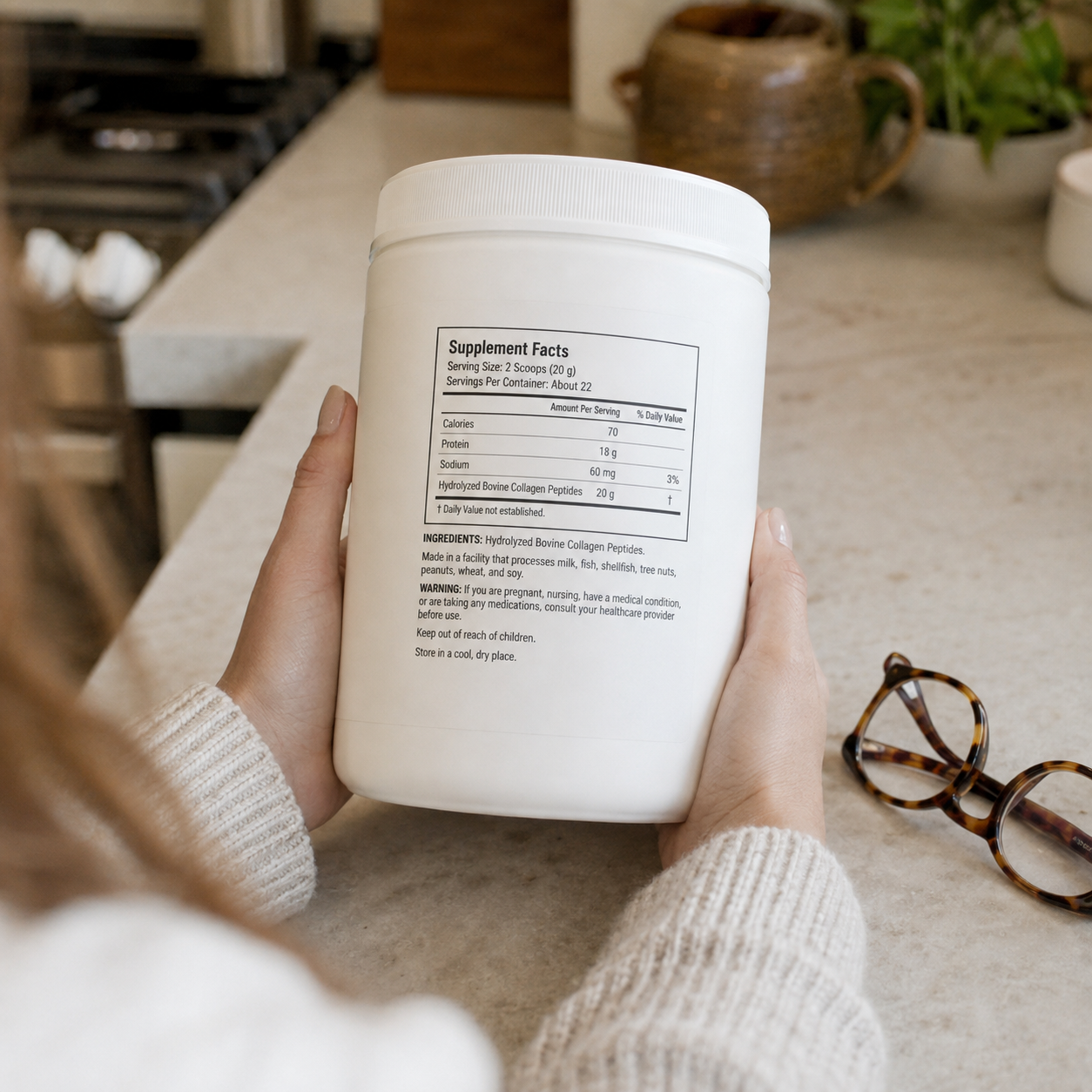 Woman reading the ingredients panel on the back of a collagen tub
