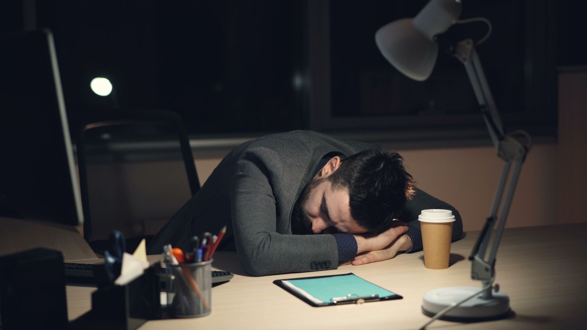 Exhausted Worker Sleeping at Desk Late Night