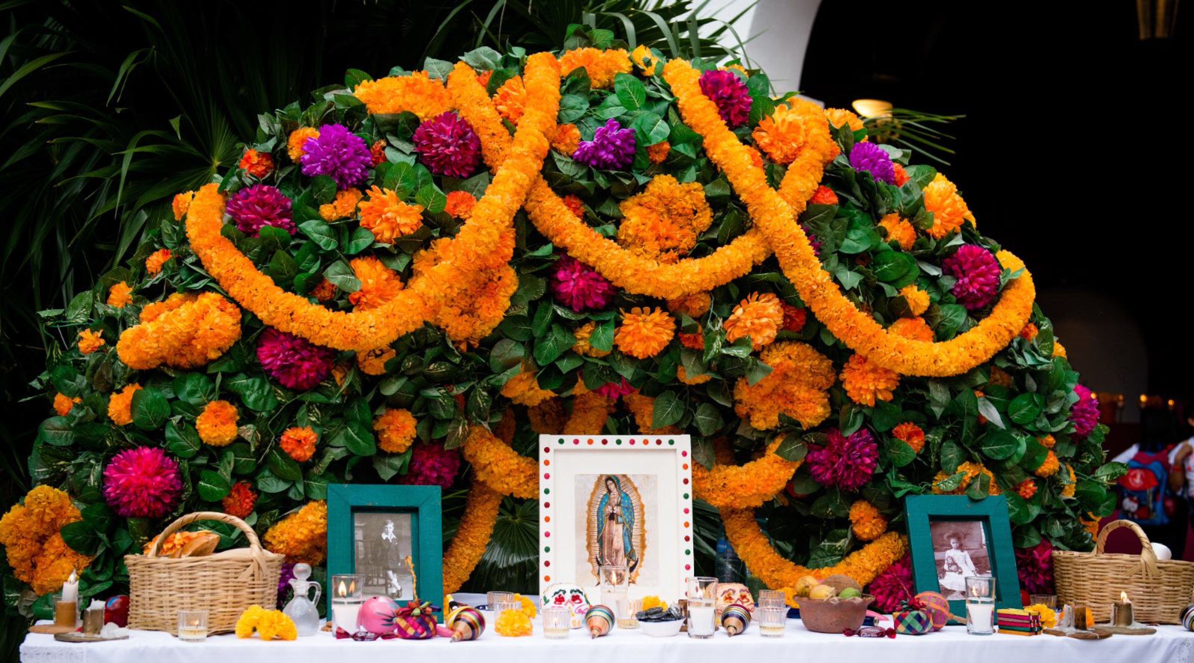 Ofrenda de Día de Muertos en Cancún, Quintana Roo (México), con flores de cempasúchil, fotografías e imagen de la Virgen de Guadalupe. | Crédito: Tati Nova photo Mexico/Shutterstock.