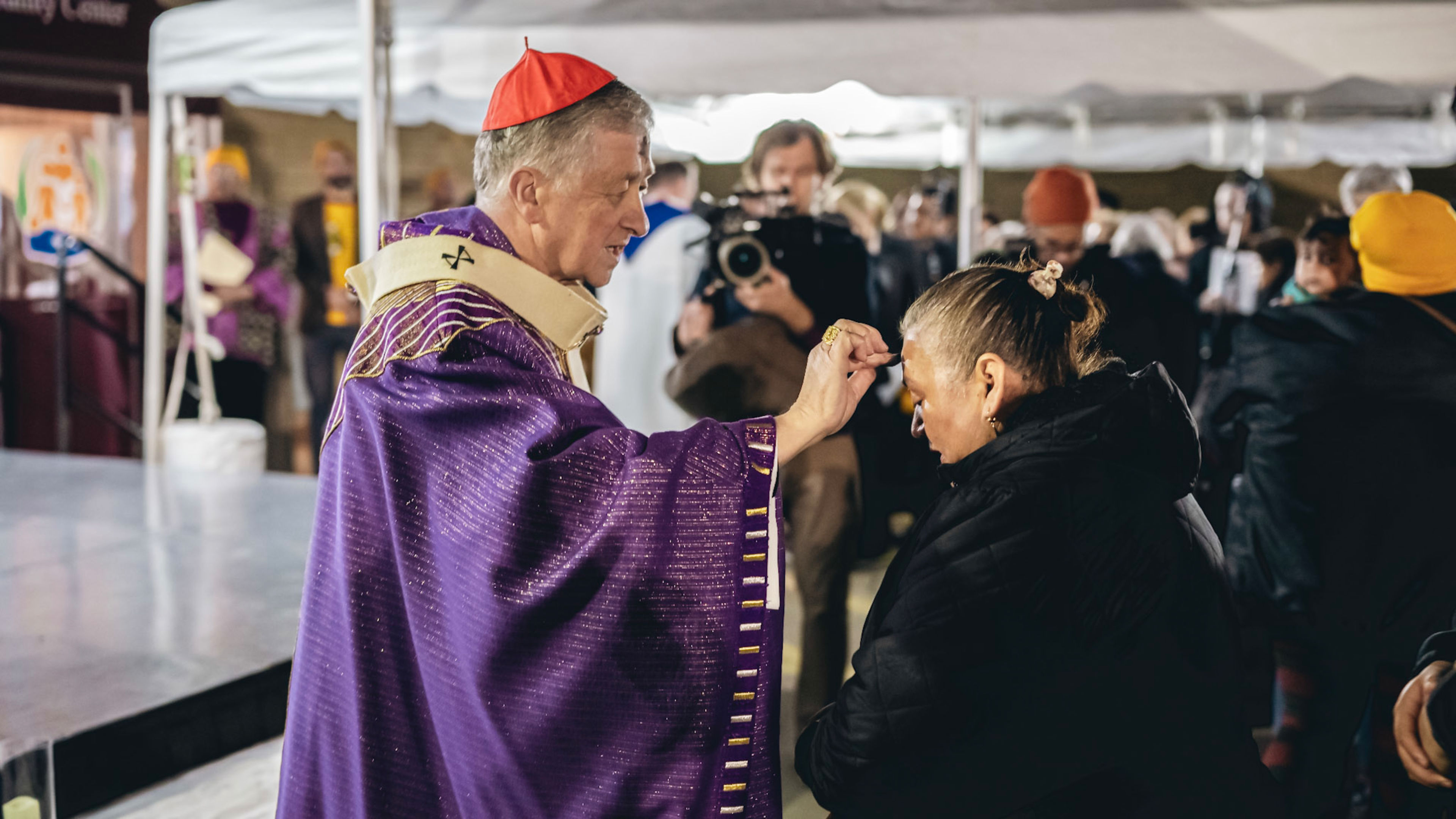 Cardinal Blase Cupich distributes ashes during an outdoor Ash Wednesday Mass in Melrose Park for families of detained and deported immigrants