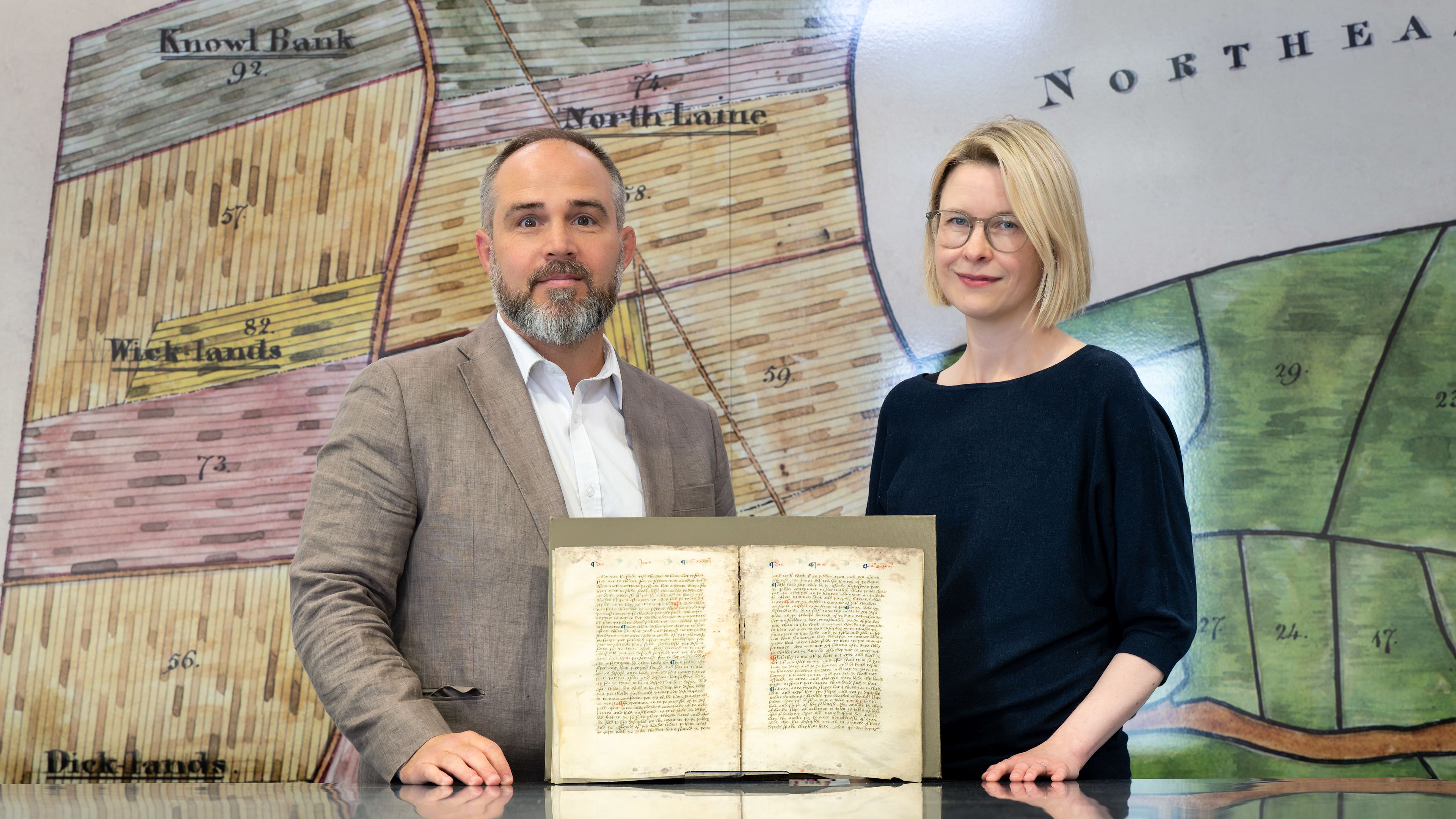 Professors James Wade and Katie Walter display a fragment of Nicholas Love’s early 15th-century “Mirror of the Blessed Life of Jesus Christ” in an undated photo at the Keep archive in Brighton, England. | Credit: Photo courtesy of the University of Sussex