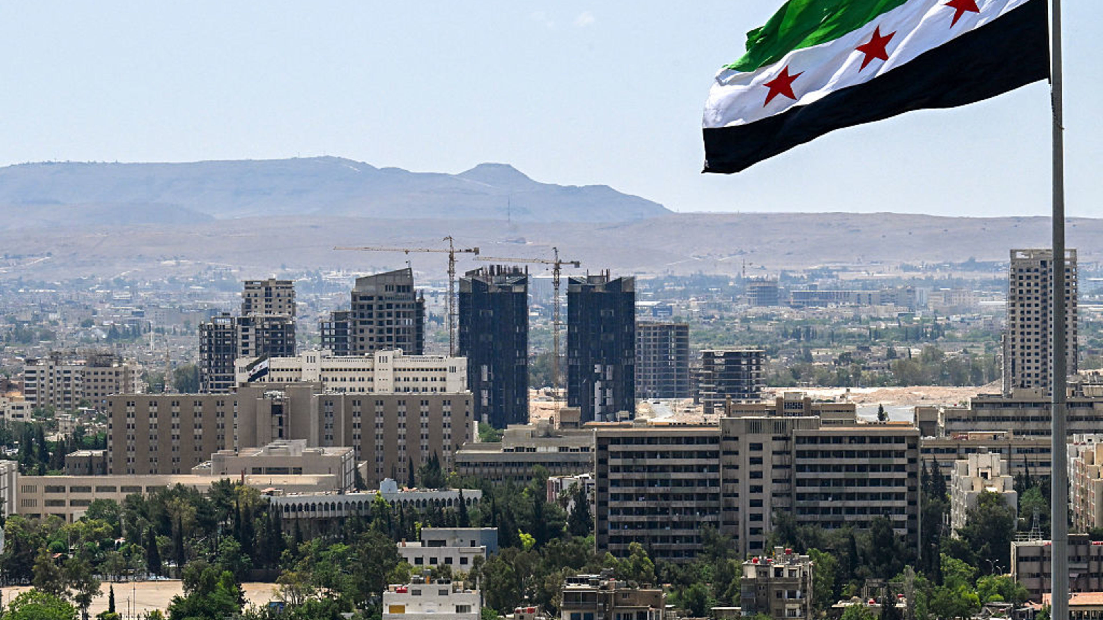 A large Syrian flag flutters above Tishreen Park in Damascus on June 4, 2025. | Credit: hLOUAI BESHARA/AFP via Getty Images