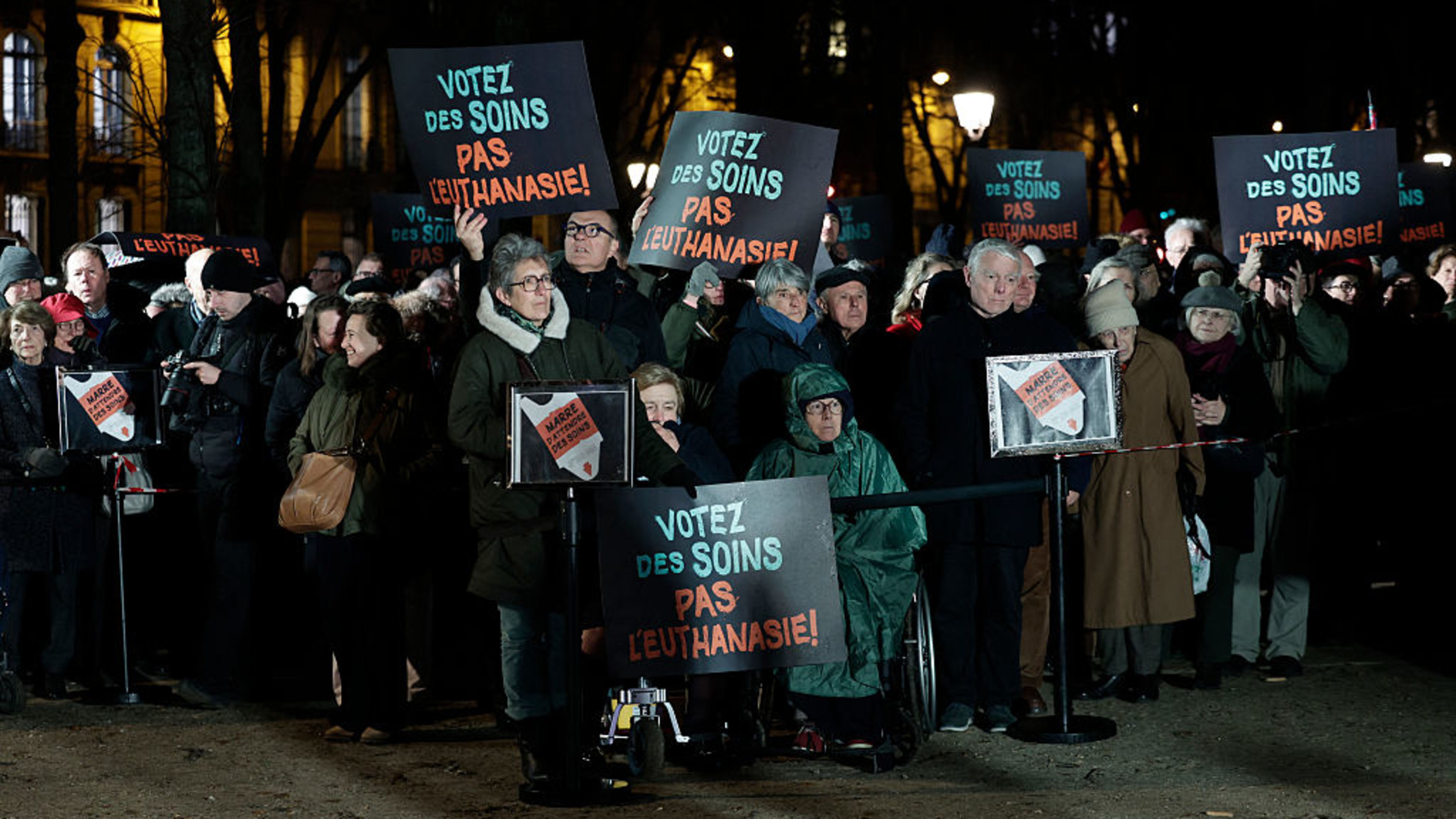 People hold placards reading “Vote for cares. Not euthanasia” during a demonstration against a bill for the creation of a right to assisted dying at Esplanade des Invalides in Paris on Feb. 16, 2026. The final vote on the bill is set to take place Wednesday, July 15, 2026. | Photo credit: STEPHANE DE SAKUTIN/AFP via Getty Images