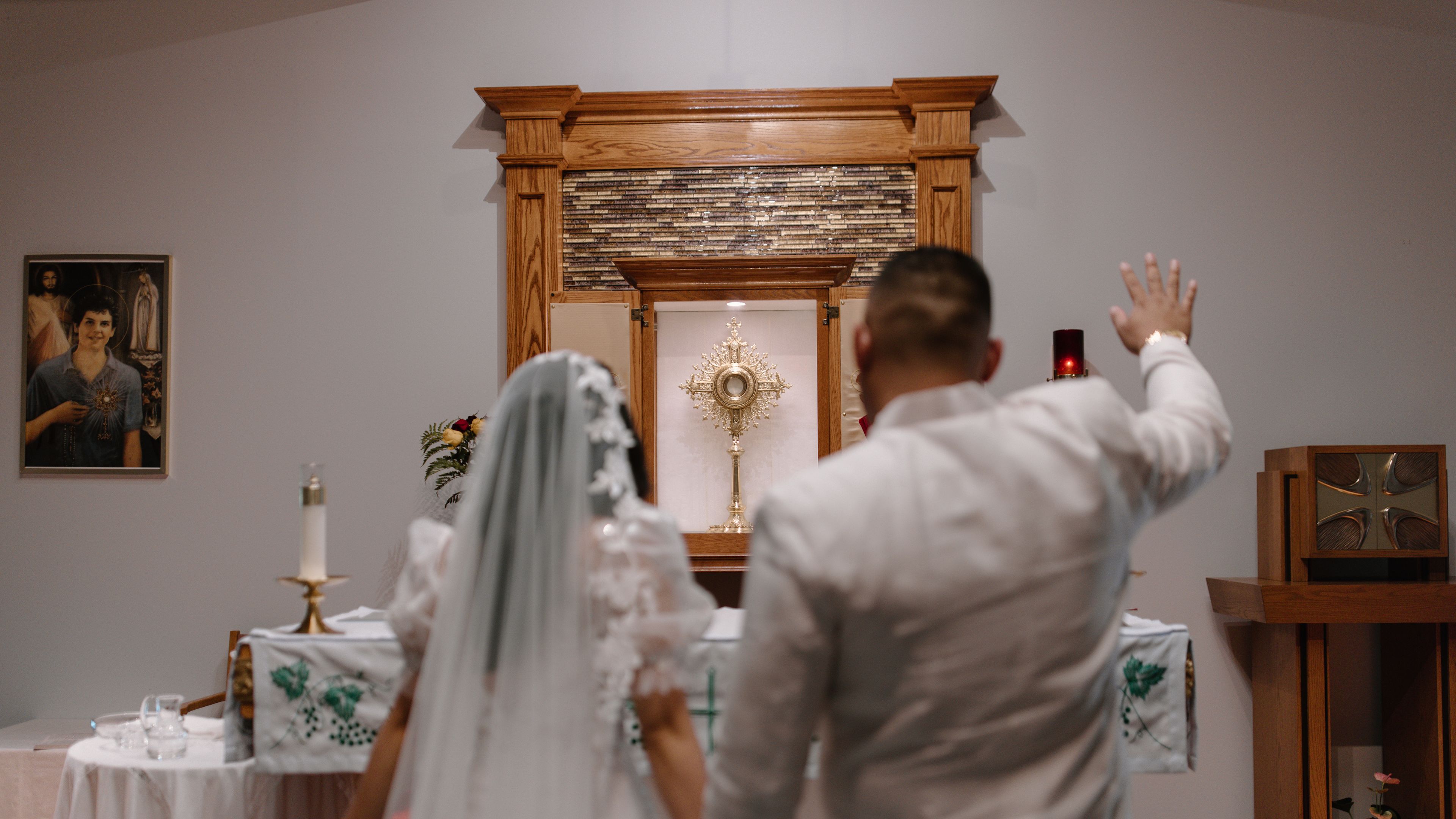 A bride and groom stand at the altar before the Most Blessed Sacrament. | Credit: Photo courtesy of Gabe Gessler/Cana