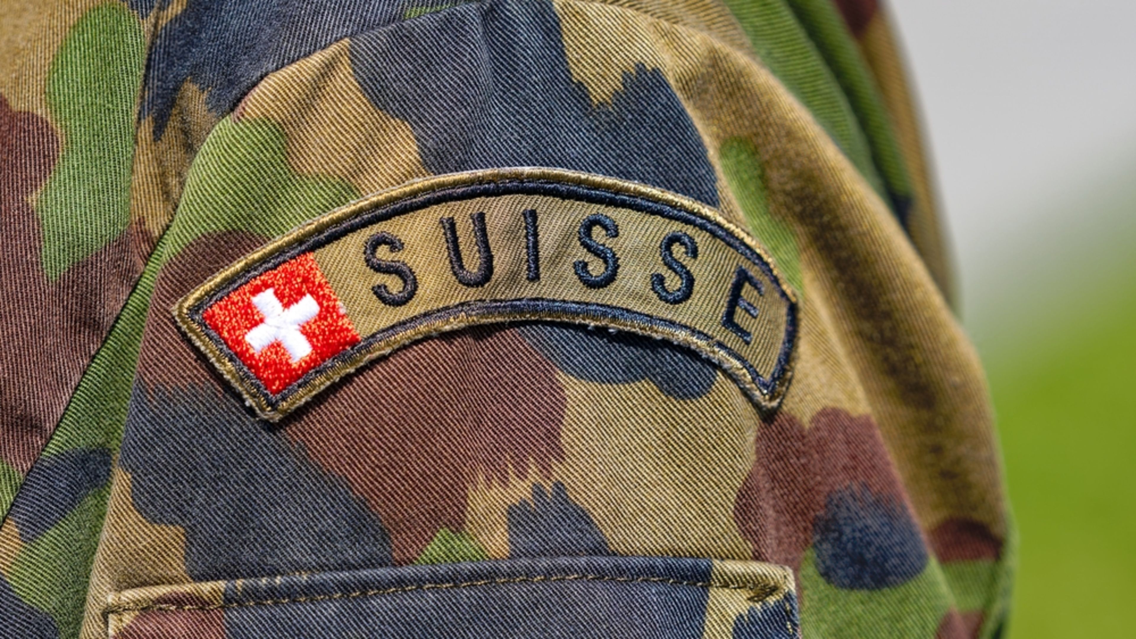 A “Suisse” patch with the flag of Switzerland adorns the camouflage uniform of a Swiss Army soldier. | Credit: Michael Derrer Fuchs/Shutterstock