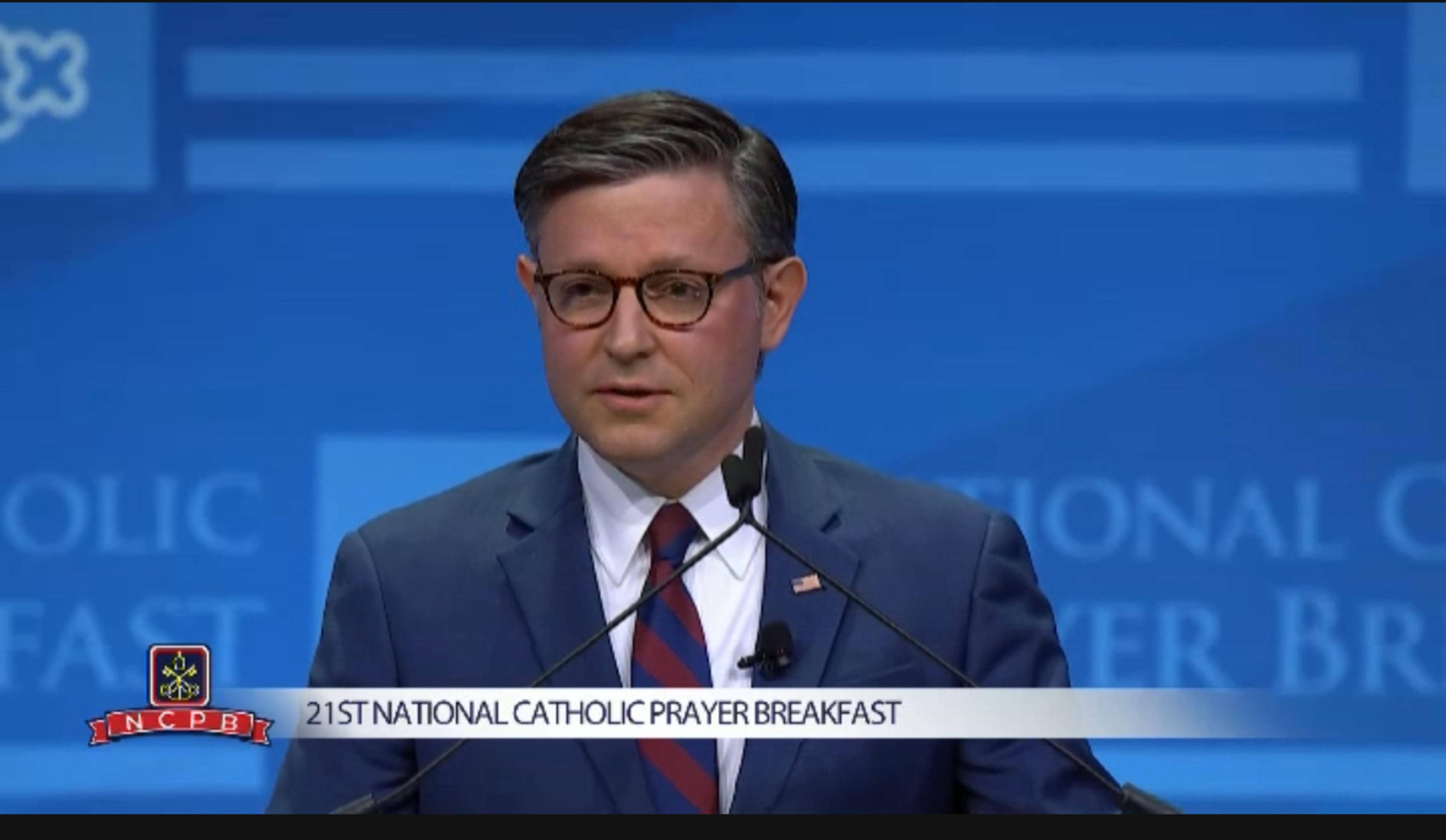 House Speaker Mike Johnson speaking at the podium during the 2026 National Catholic Prayer Breakfast in Washington D.C.