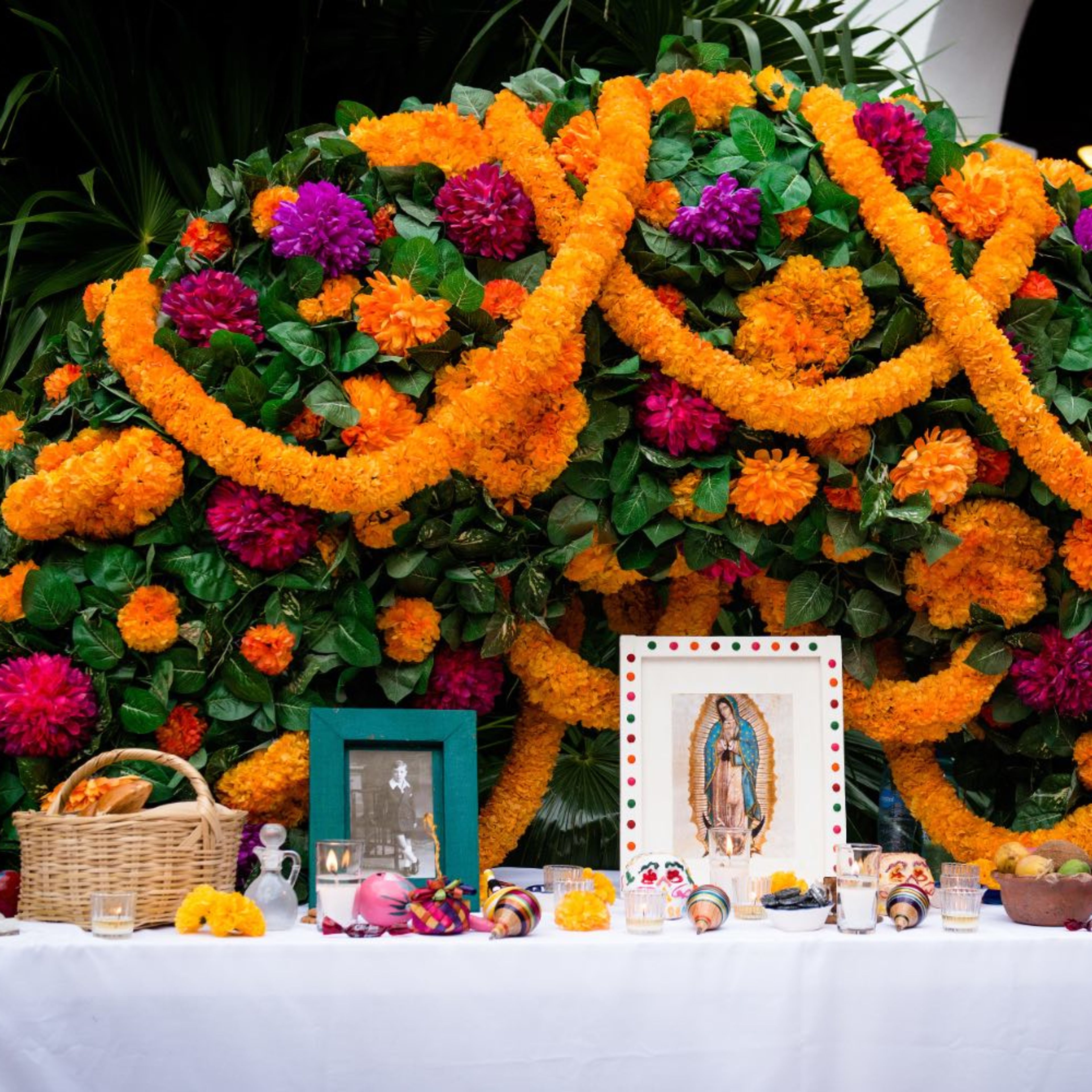 Ofrenda de Día de Muertos en Cancún, Quintana Roo (México), con flores de cempasúchil, fotografías e imagen de la Virgen de Guadalupe. | Crédito: Tati Nova photo Mexico/Shutterstock.