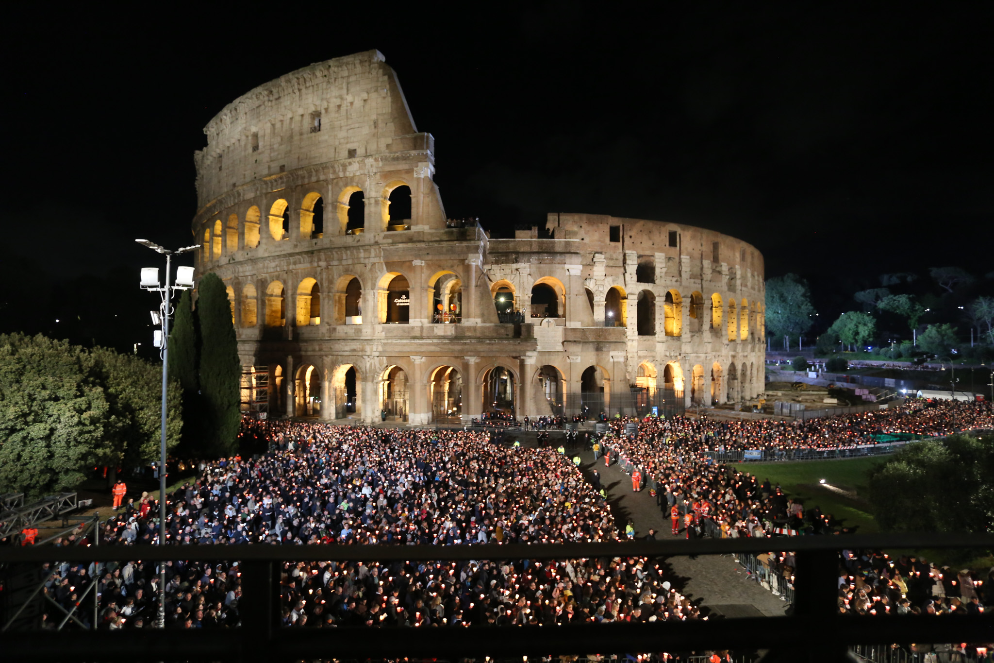 Thousands of faithful holding candles surround the illuminated Colosseum in Rome during the traditional Stations of the Cross devotion on Good Friday, April 18, 2025. | Credit: Zofia Czubak/EWTN News