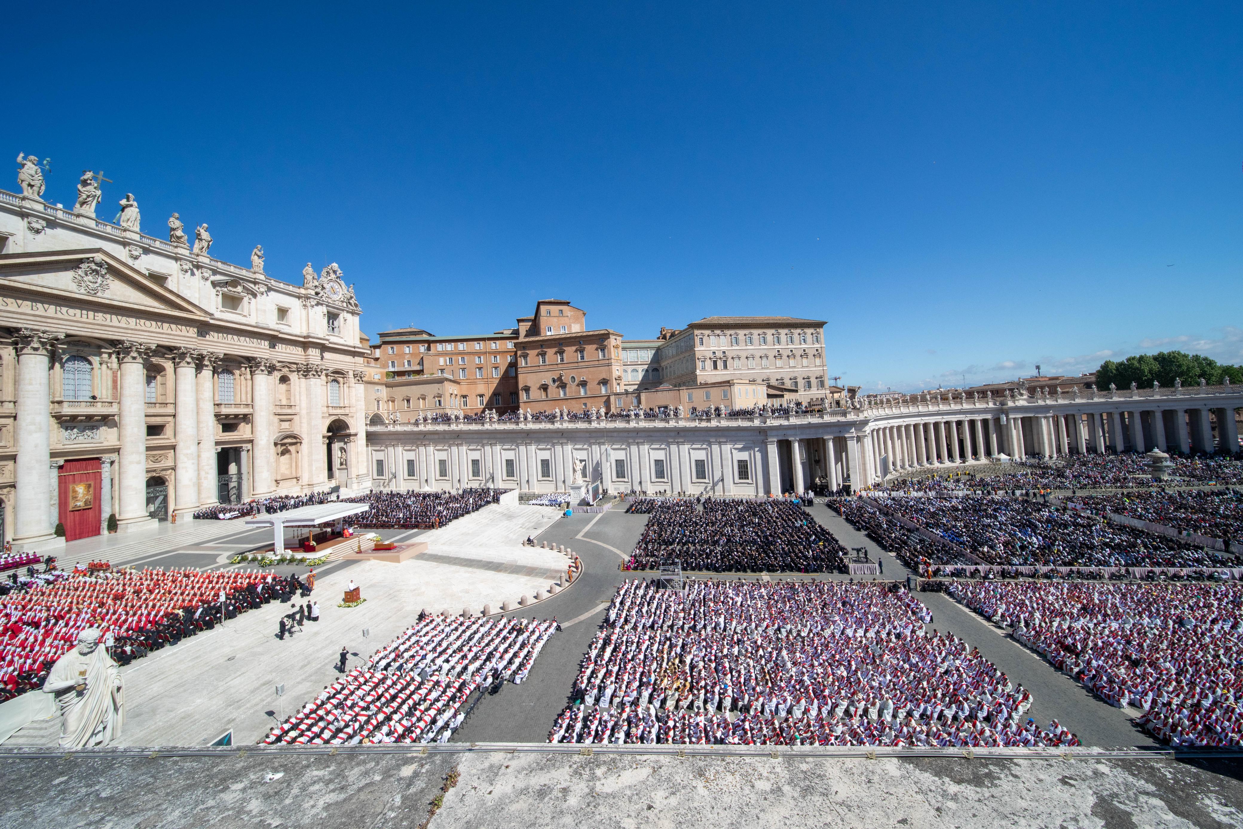 An aerial view of St. Peter's Square filled with thousands of mourners, clergy, and dignitaries gathered for Pope Francis's funeral Mass under clear blue skies in Vatican City on April 26, 2025.` - Credit: Daniel Ibáñez/CNA