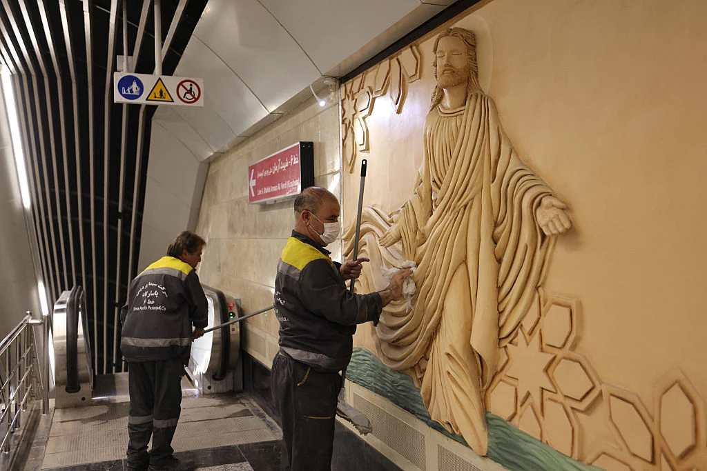 A worker polishes a relief sculpture of Jesus Christ at the newly-opened Maryam Moghaddas (Virgin Mary) metro station near the Sarkis Cathedral of the Armenians in Tehran on Oct. 18, 2025. Credit: ATTA KENARE/AFP via Getty Images
