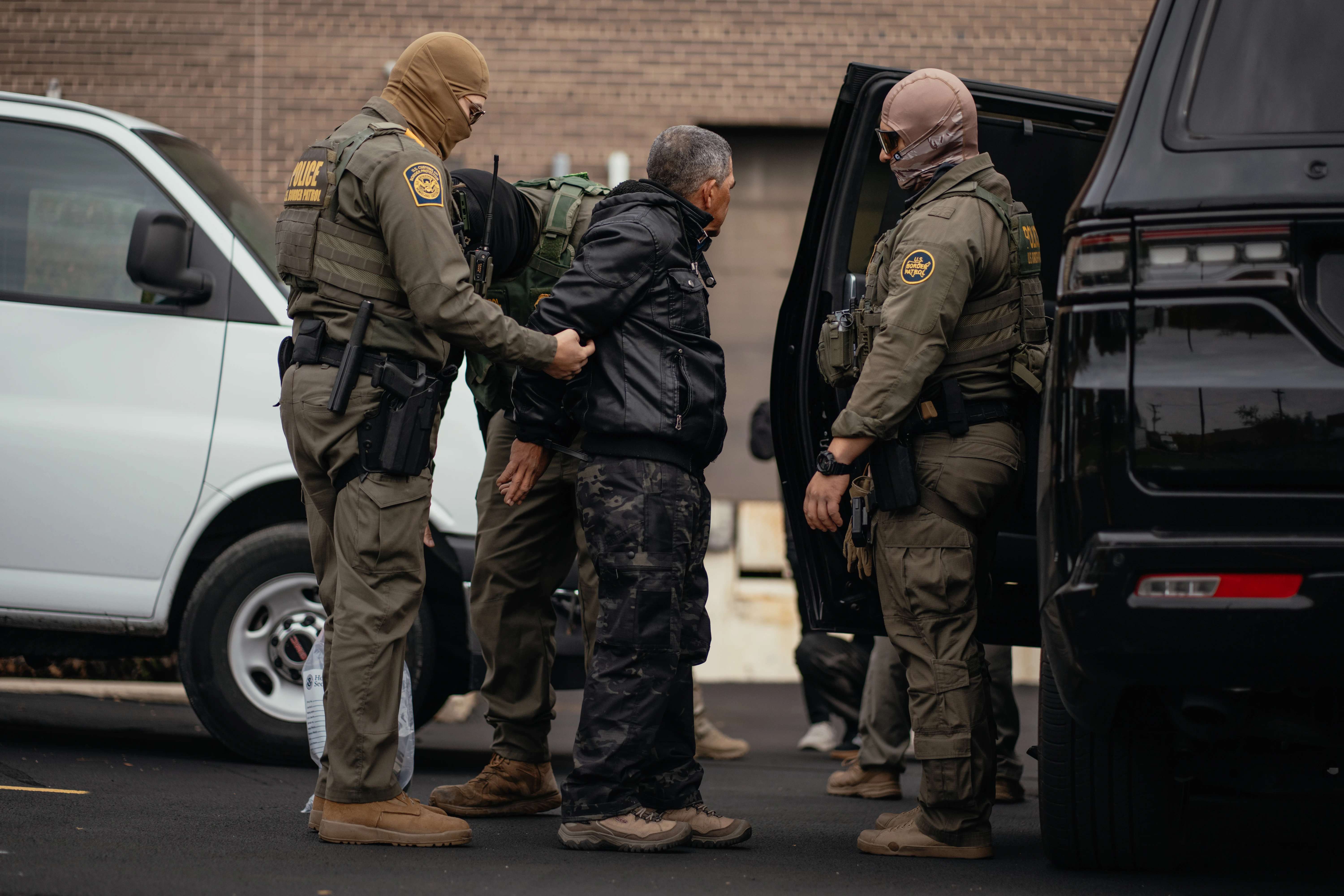 A person detained is taken to a parking lot on the far north side of the city before being transferred to an Immigration and Customs Enforcement facility in Chicago on Oct. 31, 2025. | Credit: Jamie Kelter Davis/Getty Images