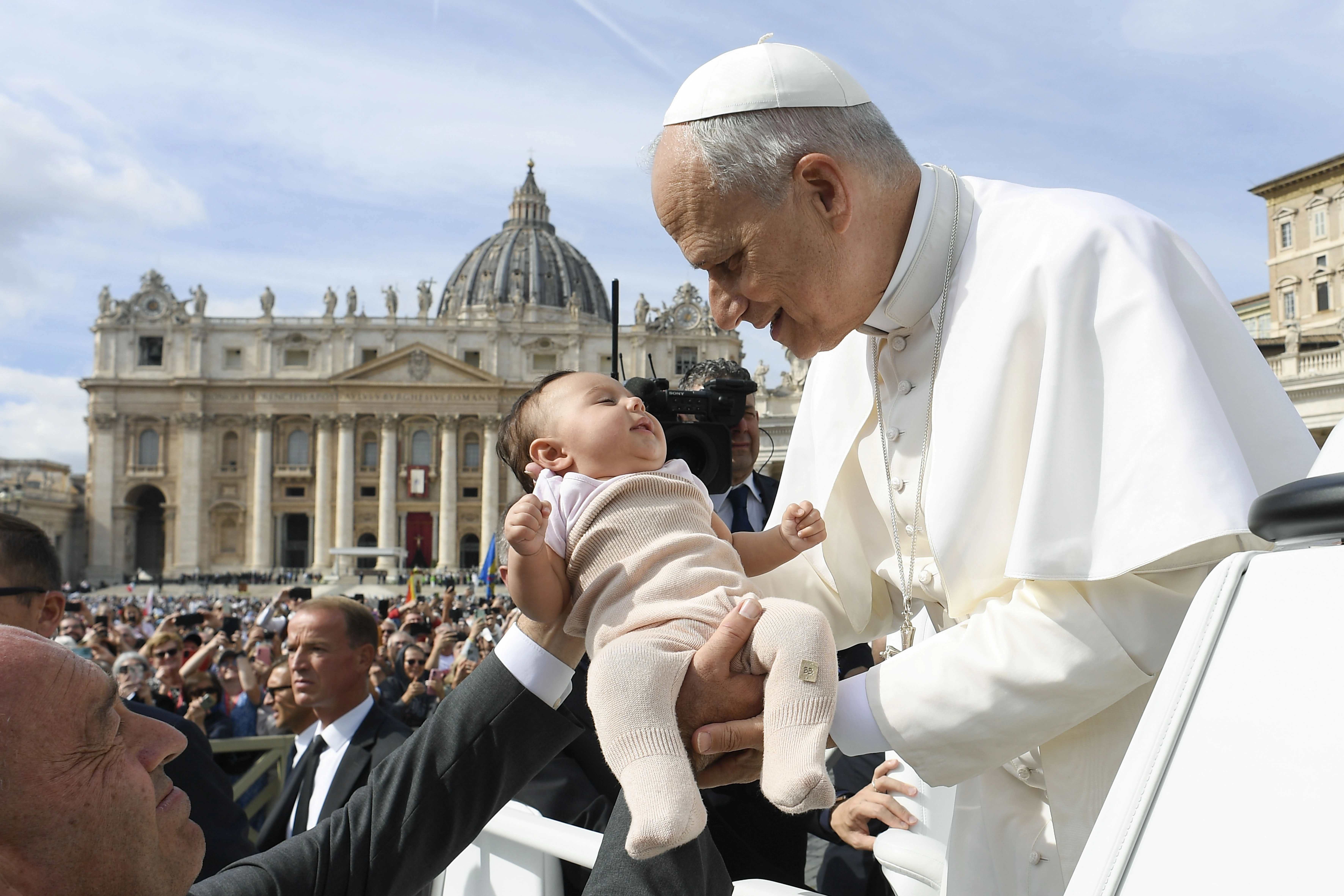 Pope Leo XIV pauses to embrace a baby in the crowd during Sunday Mass in St. Peter’s Square on Oct. 12, 2025. Credit: Vatican Media