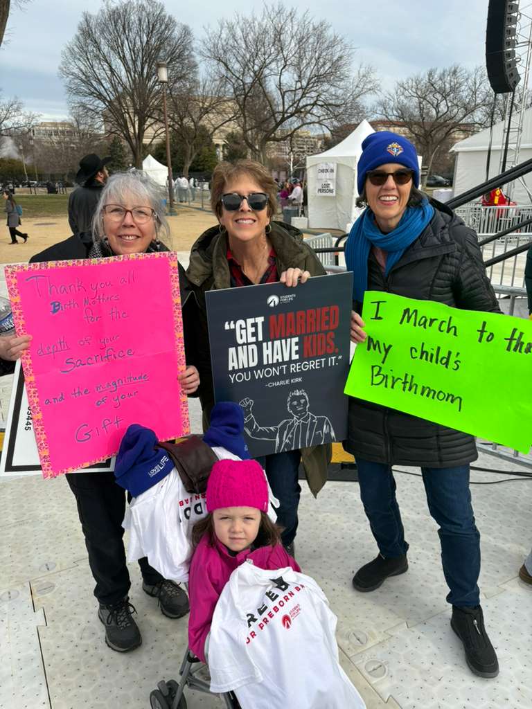 Left to right: Sisters Rita Dirkes (Granby, Massachusetts), Peg Bono (Leawood, Kansas), and Molly Judge (Ashlyn, Massachusetts) with Molly’s adoptive daughter hold their signs at the March for Life on...