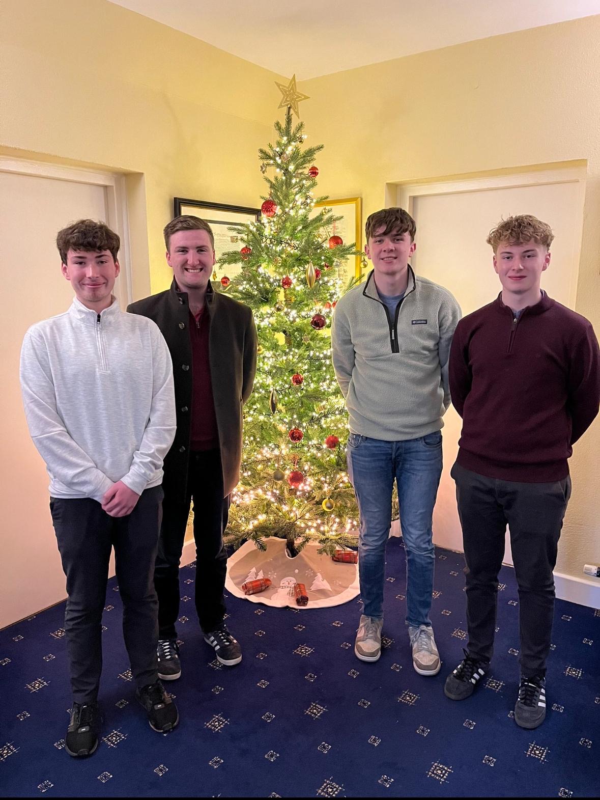 In front of Bishop Denis Nulty’s Christmas tree after tea and biscuits following Mass: Neil Patterson, Luke Doogue, Dylan Byrne, and Stephen Patterson. | Credit: Photo courtesy of Luke Doogue