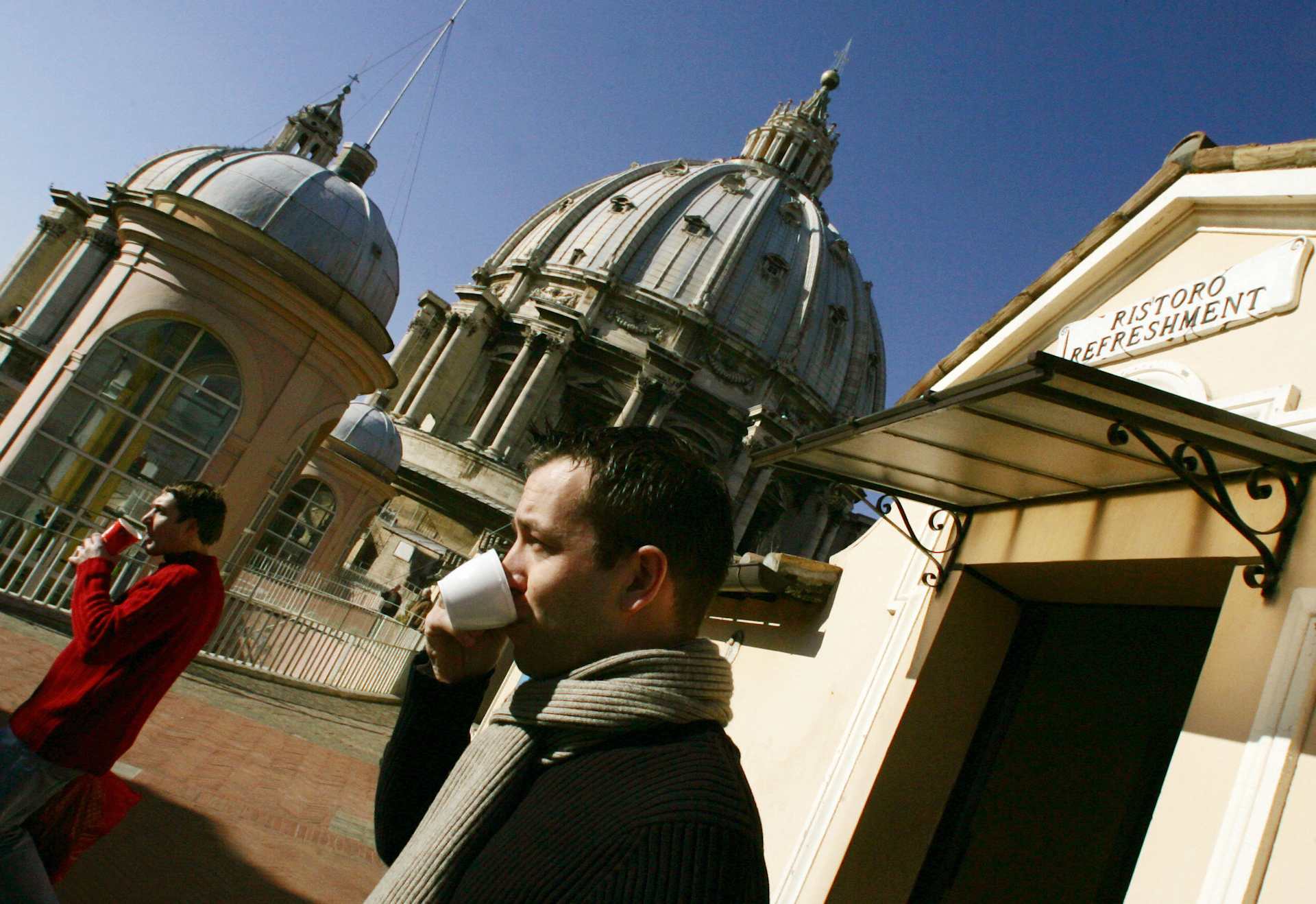 A tourist drinks a coffee on the terrace of St. Peter’s Basilica at the Vatican, at the base of the towering dome designed by Michelangelo, Monday, Jan. 17, 2005. | Credit: GIULIO NAPOLITANO/AFP via Getty Images