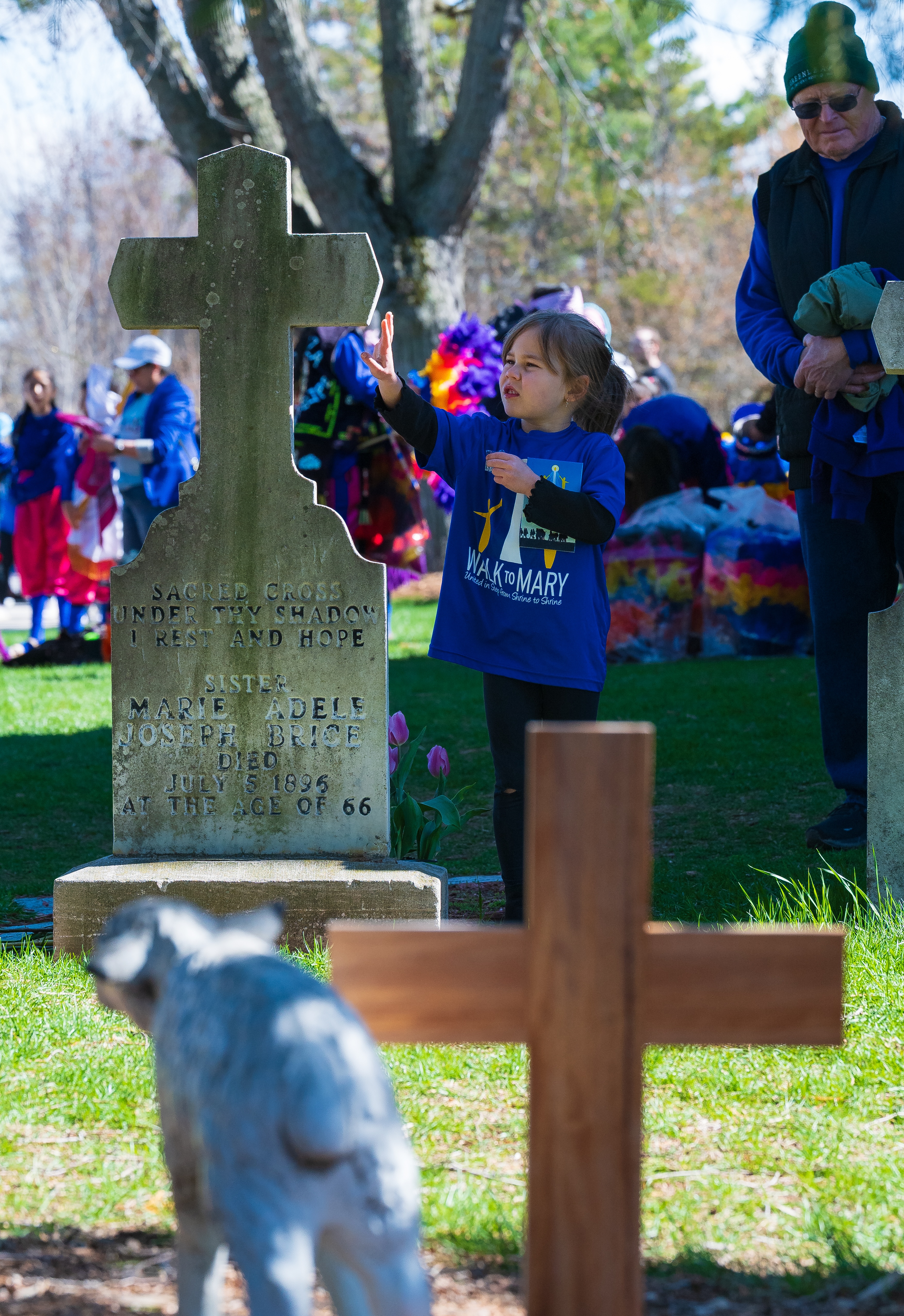 A child at Adele Brice’s grave in Champion, Wisconsin. | Credit: Photo courtesy of the Champion Shrine