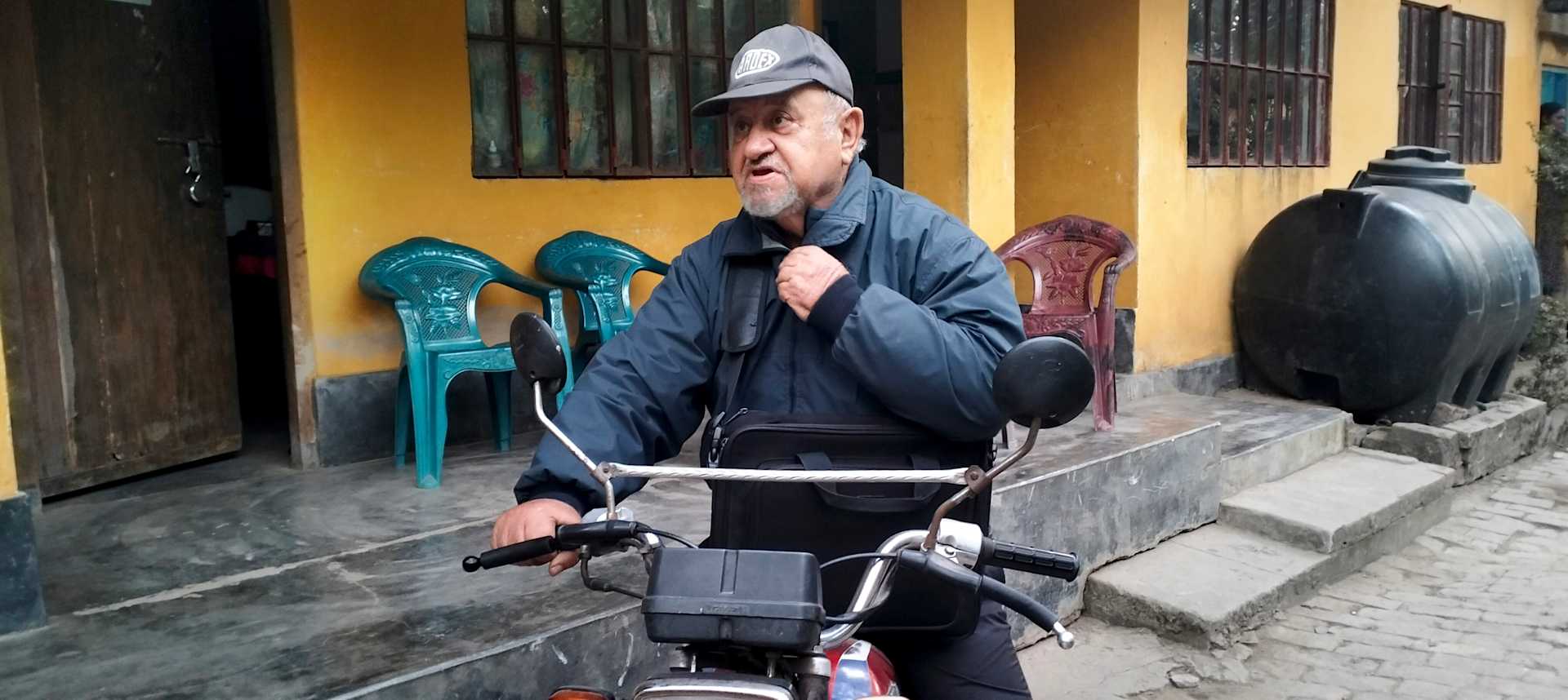 Father Luigi Paggi sits on his motorcycle, which he used for years to travel to Munda villages in coastal Bangladesh before his health declined. | Credit: Stephan Uttom Rozario