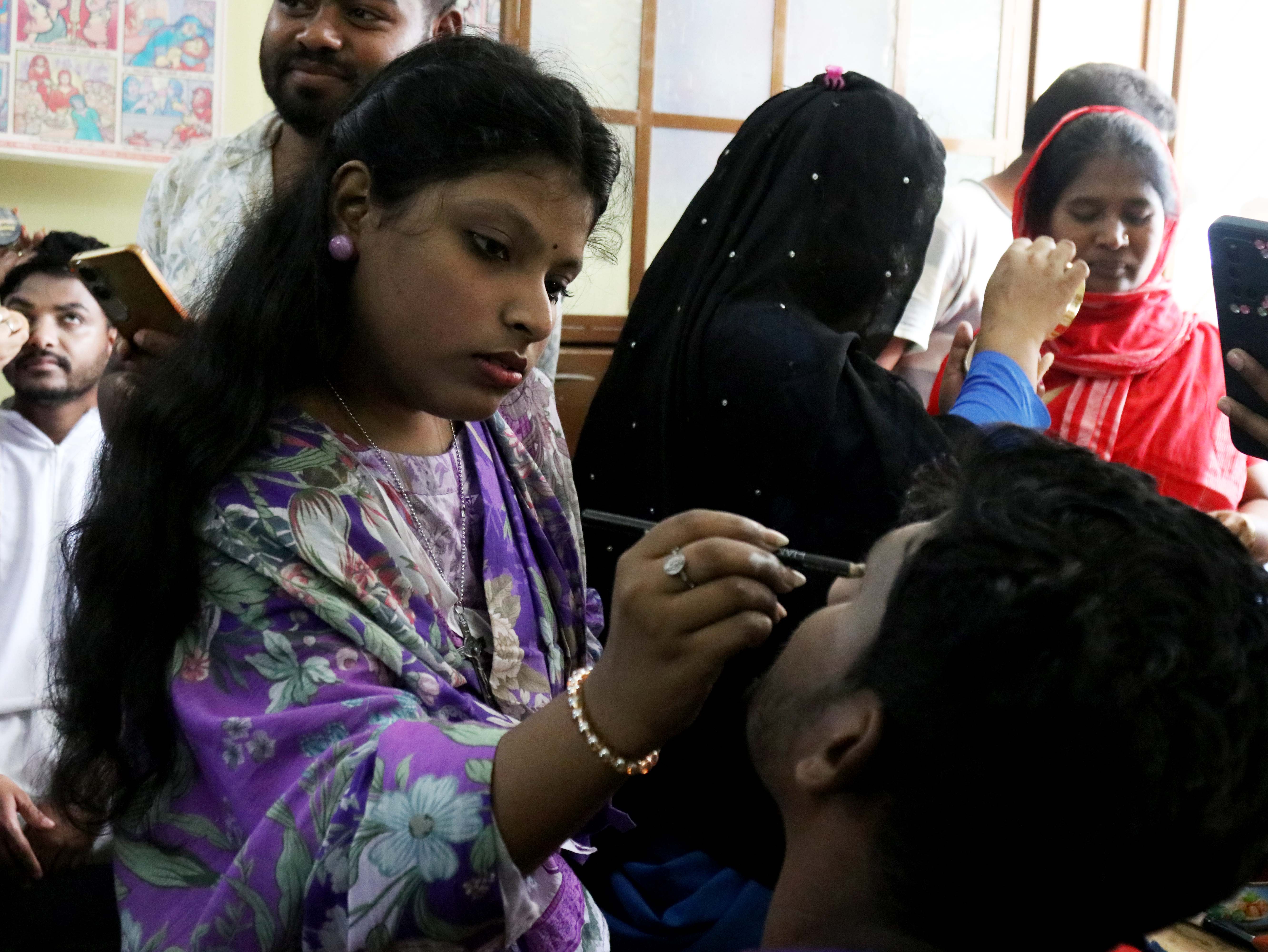 A parishioner applies makeup to a participant ahead of a living Way of the Cross
at the Jesus Worker Center in Gazipur, Bangladesh, Friday, April 3, 2026. | Credit:
Stephan Uttom Rozario