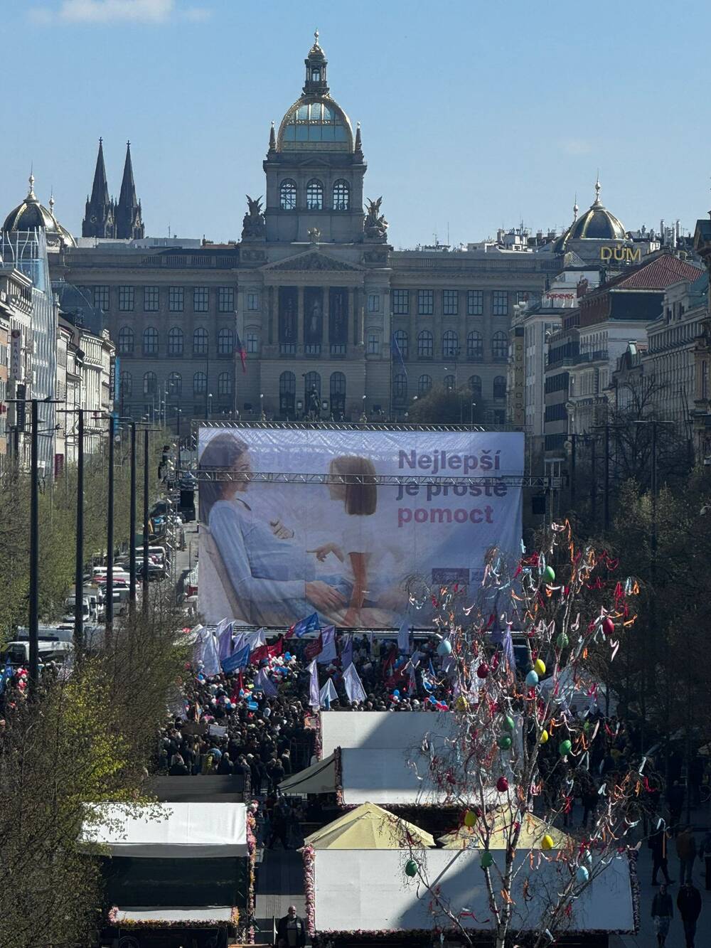 A banner reads “The best is just to help” in Czech at the March for Life rally in Wenceslas Square, Prague, with the National Museum visible in the background, on April 11, 2026. | Credit: Hnutí Pro život ČR