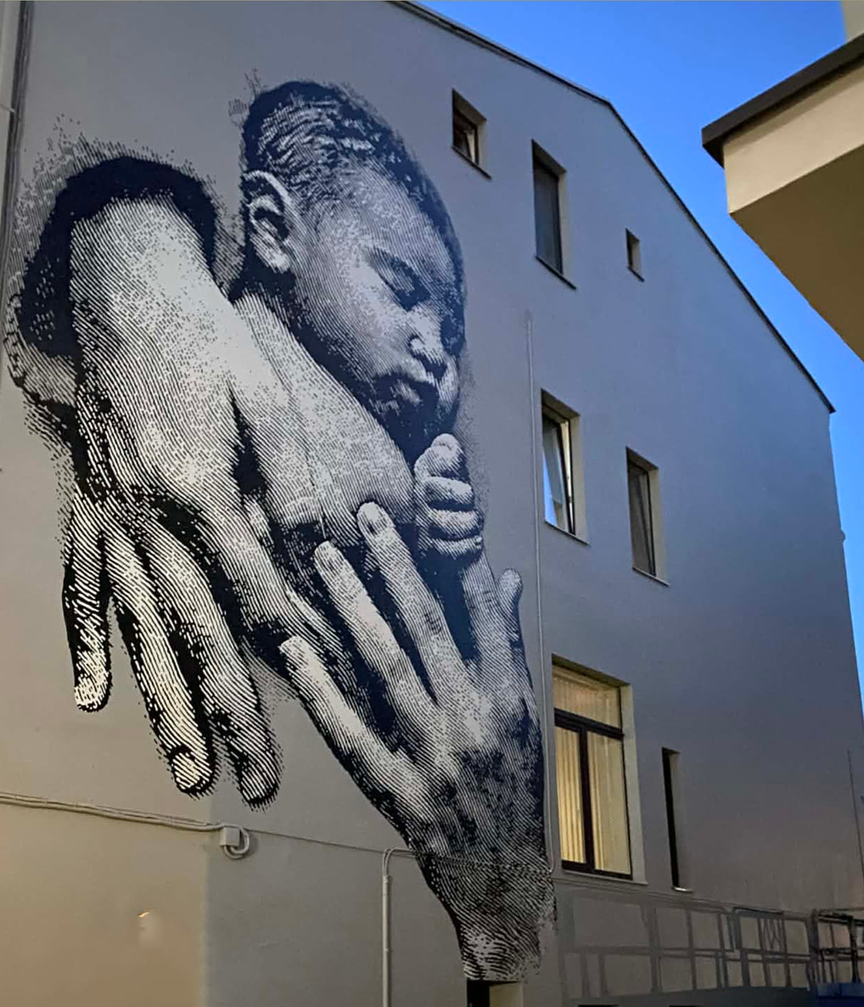 A mural on the facade of the Kaunas Christian Maternity Home depicts a newborn cradled in adult hands, a visual signature of the institution’s pro-life identity. | Credit: Photo courtesy of organizers of the “Let’s Save the Kaunas Maternity Home” initiative