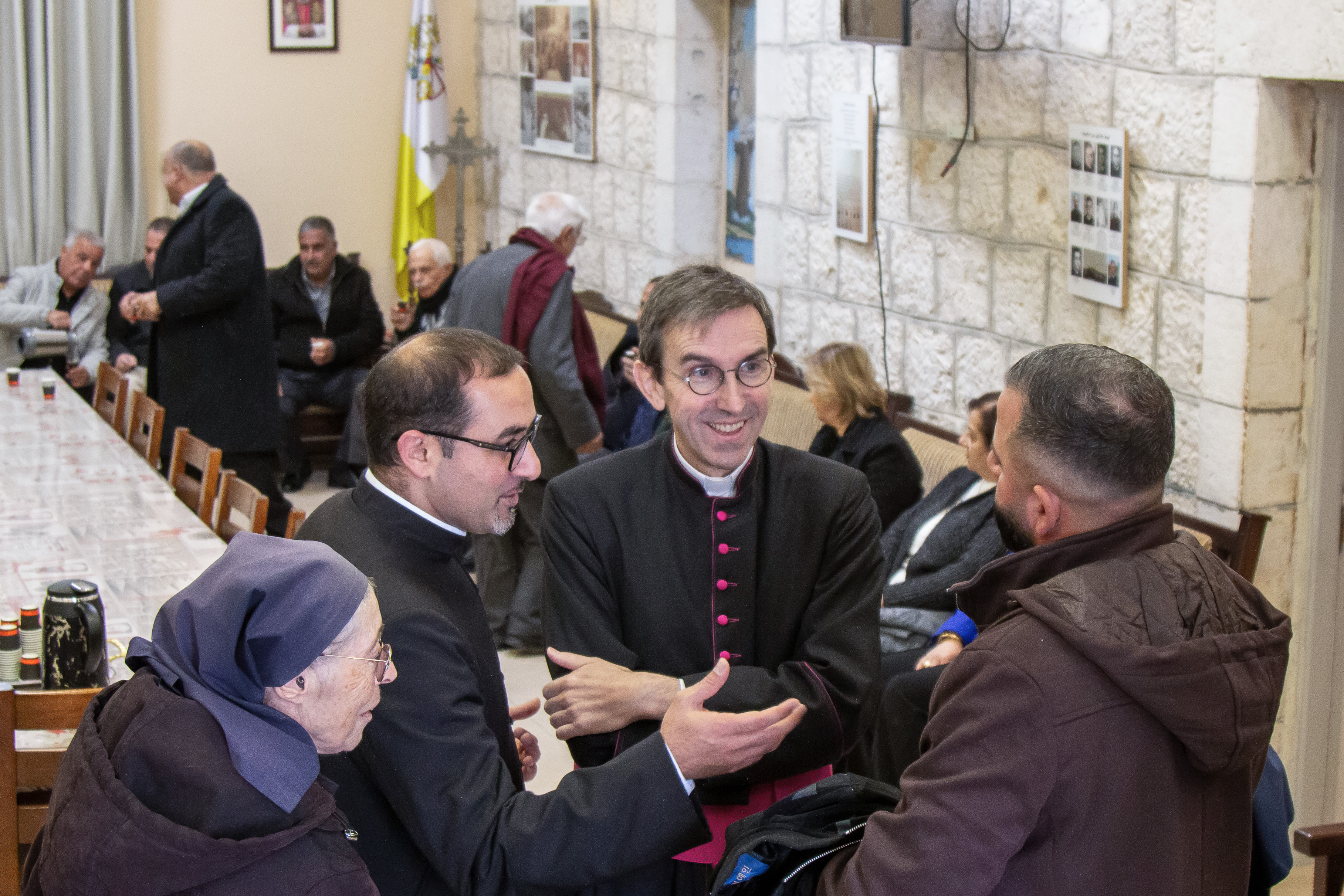 Monsignor Hugues de Woillemont talks with parishioners during a pastoral visit to Christ the Redeemer Latin Parish in Taybeh in the central West Bank. | Credit: Sanad Sahelia