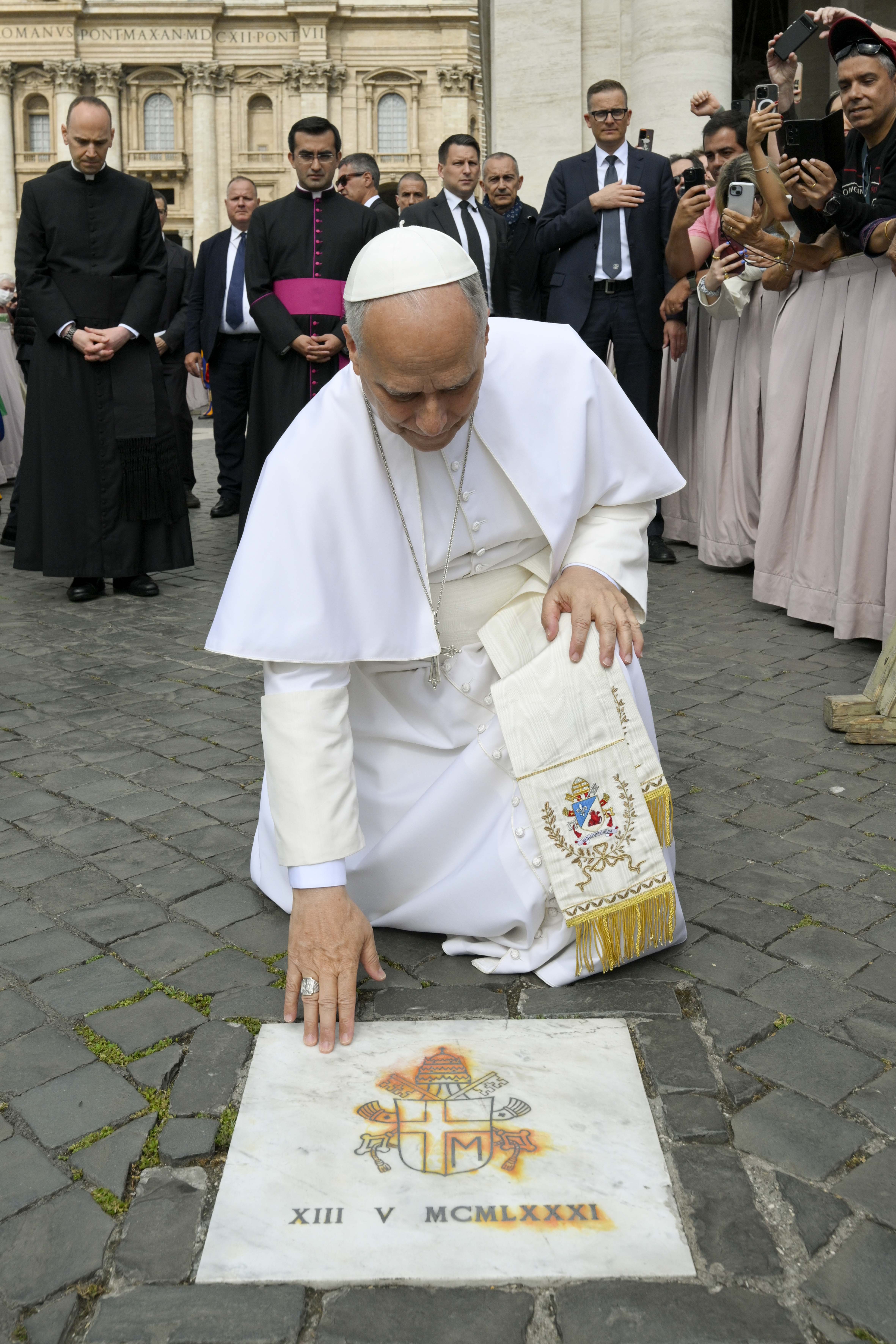 Pope Leo XIV touches the plaque marking the spot in St. Peter’s Square where St. John Paul II was shot in an assassination attempt on May 13, 1981. Leo stopped at the plaque during his own general audience on the feast of Our Lady of Fátima, May 13, 2026. | Credit: Vatican Media